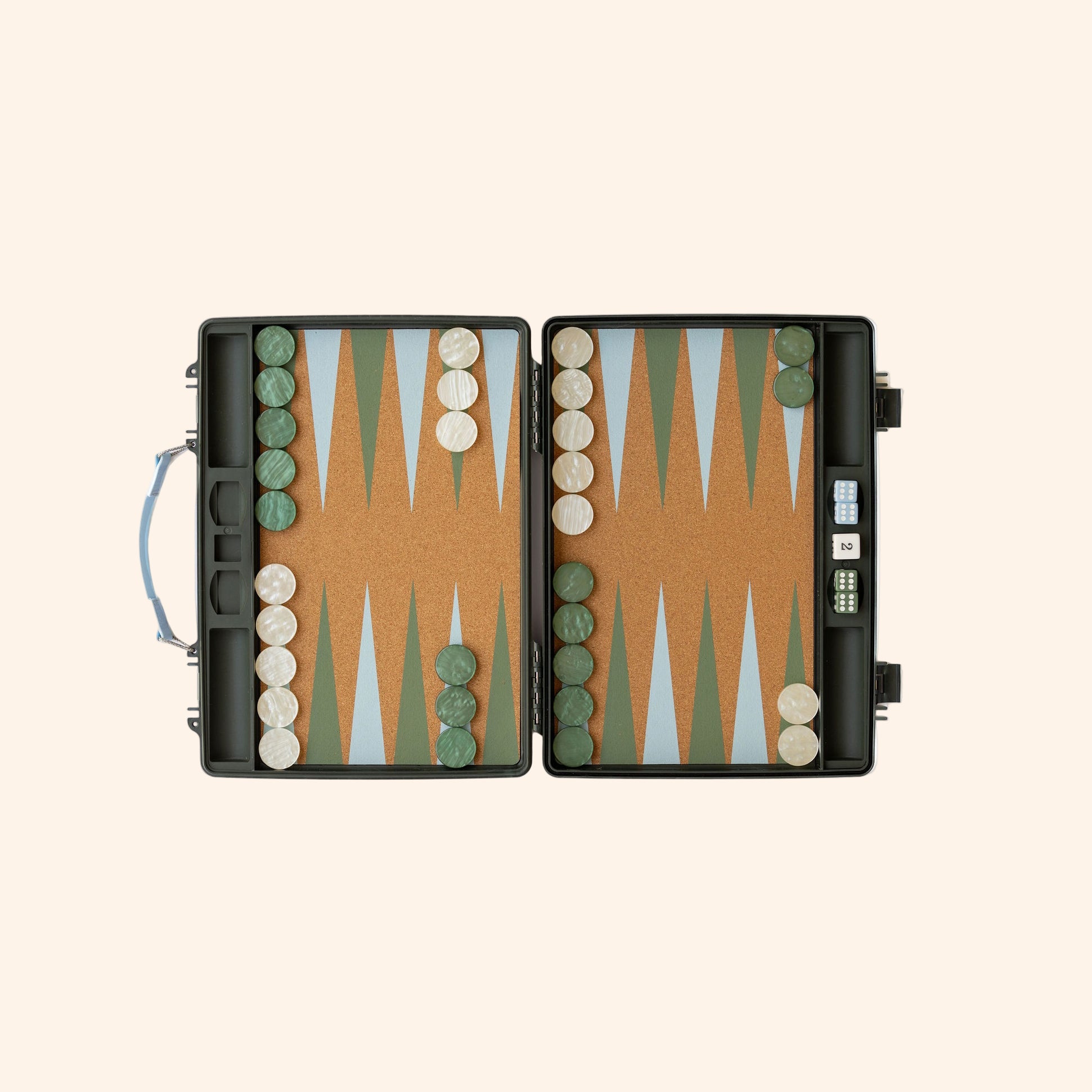 Open backgammon board with orange cork playing surface featuring alternating green and beige triangles, grey case with handle, dice and checkers arranged on board