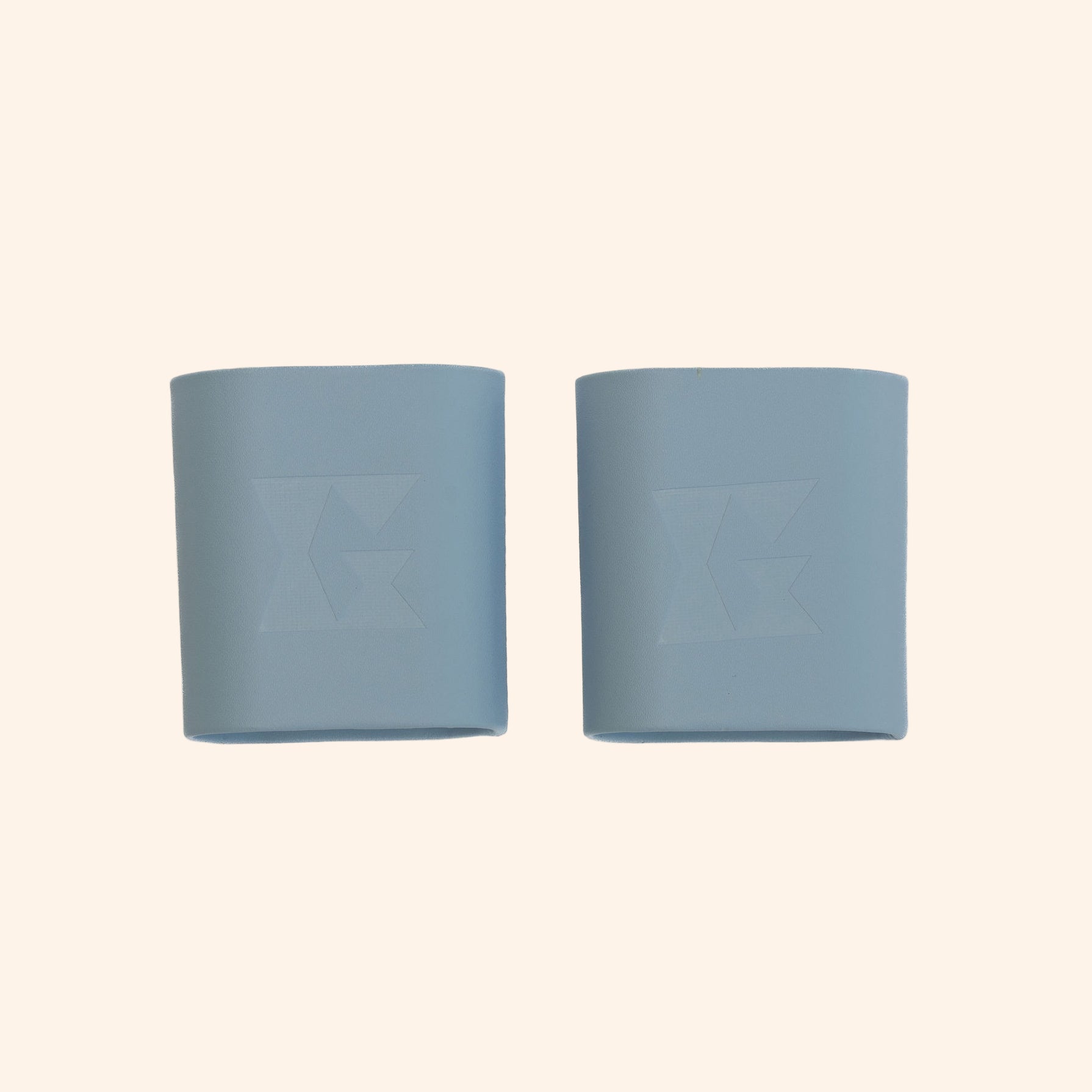 Pair of light blue dice cups with Gammn logo embossed on each, side by side on white background