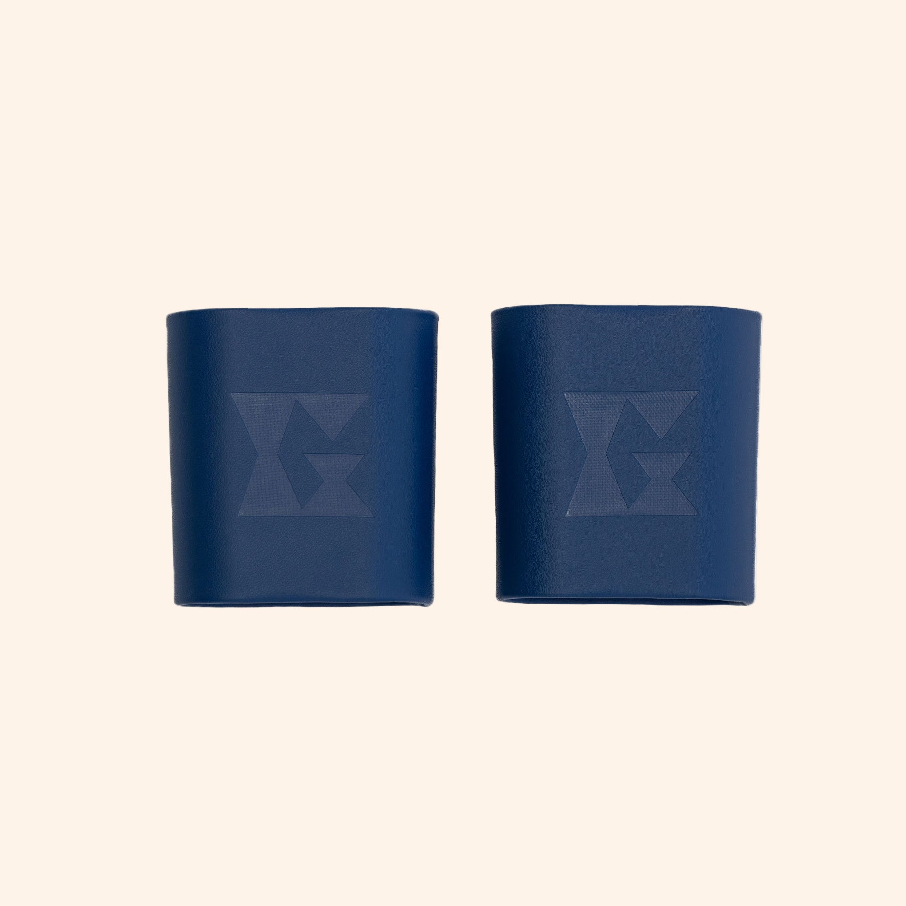 Pair of blue leather dice cups with Gammn logo embossed on each, side by side on white background
